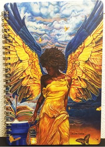 Angelic Guidance journal. This inspiring journal features cover art by Buena Johnson. It has lined pages with a ribbon bookmark, an elastic band closure and a clear zippered pouch for small objects. It also includes an inspirational Bible Scripture at the bottom of each page. Perfect for the home, school, or office. size: 5.5" x 8.5" 140 lined pages